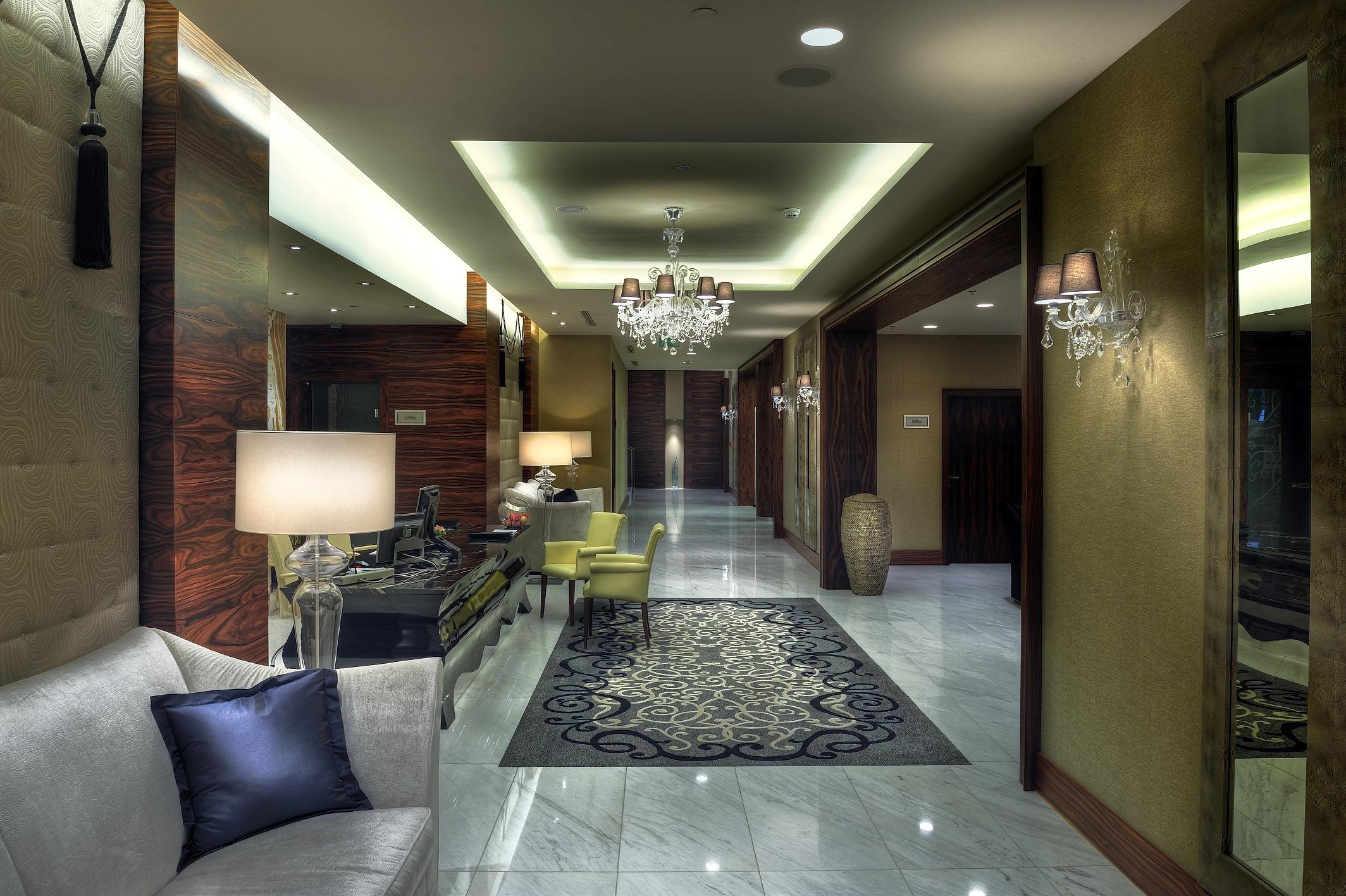 a hallway with a chandelier and chairs