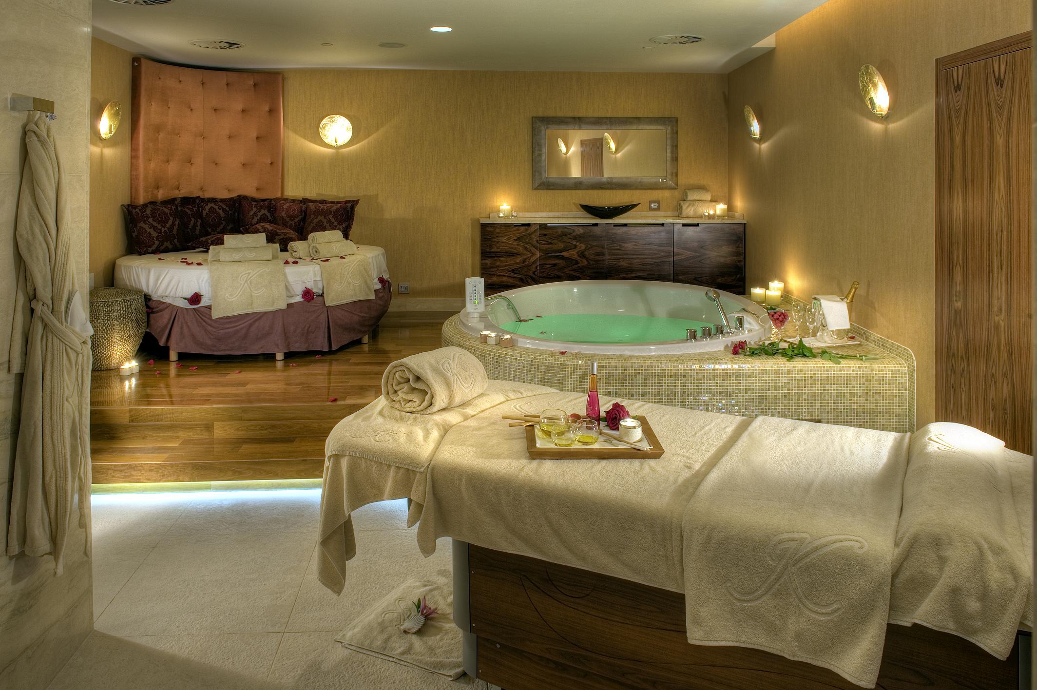 a room with a hot tub and massage table