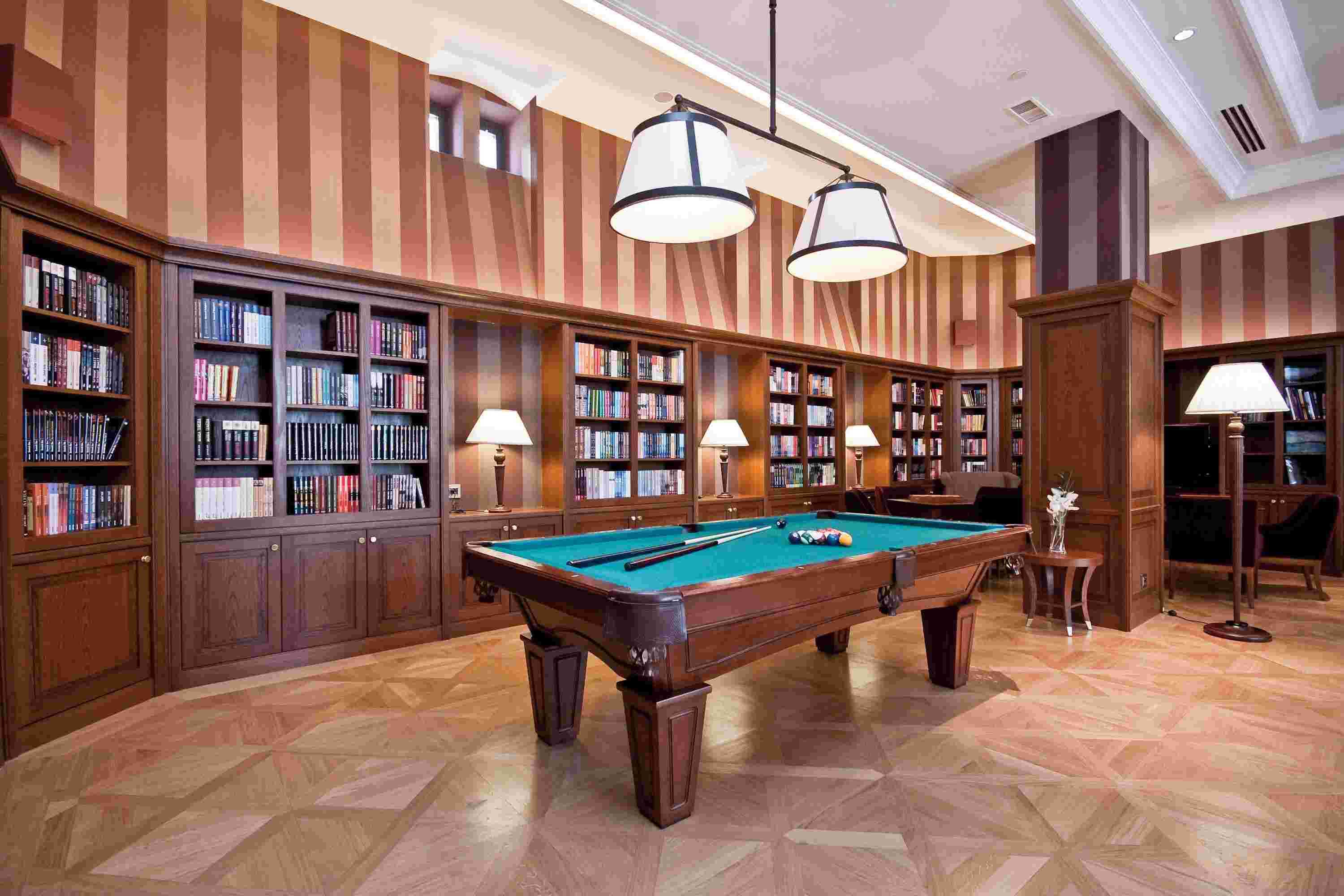 a pool table in a room with bookshelves