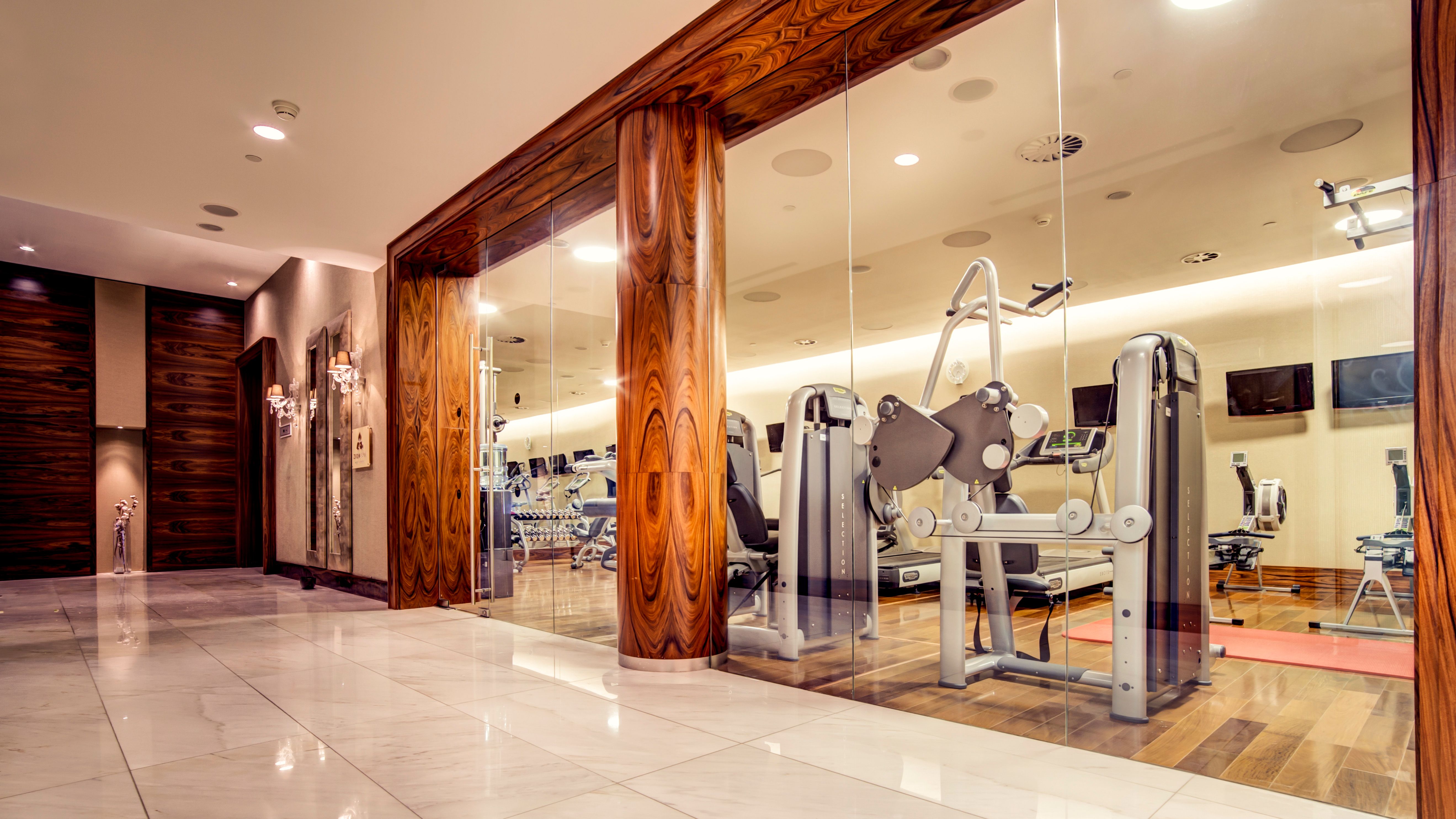 a gym with exercise equipment in front of glass walls