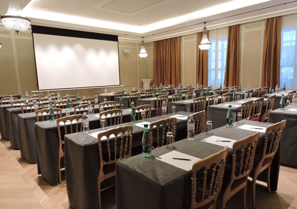 a room with tables and chairs and a projector screen