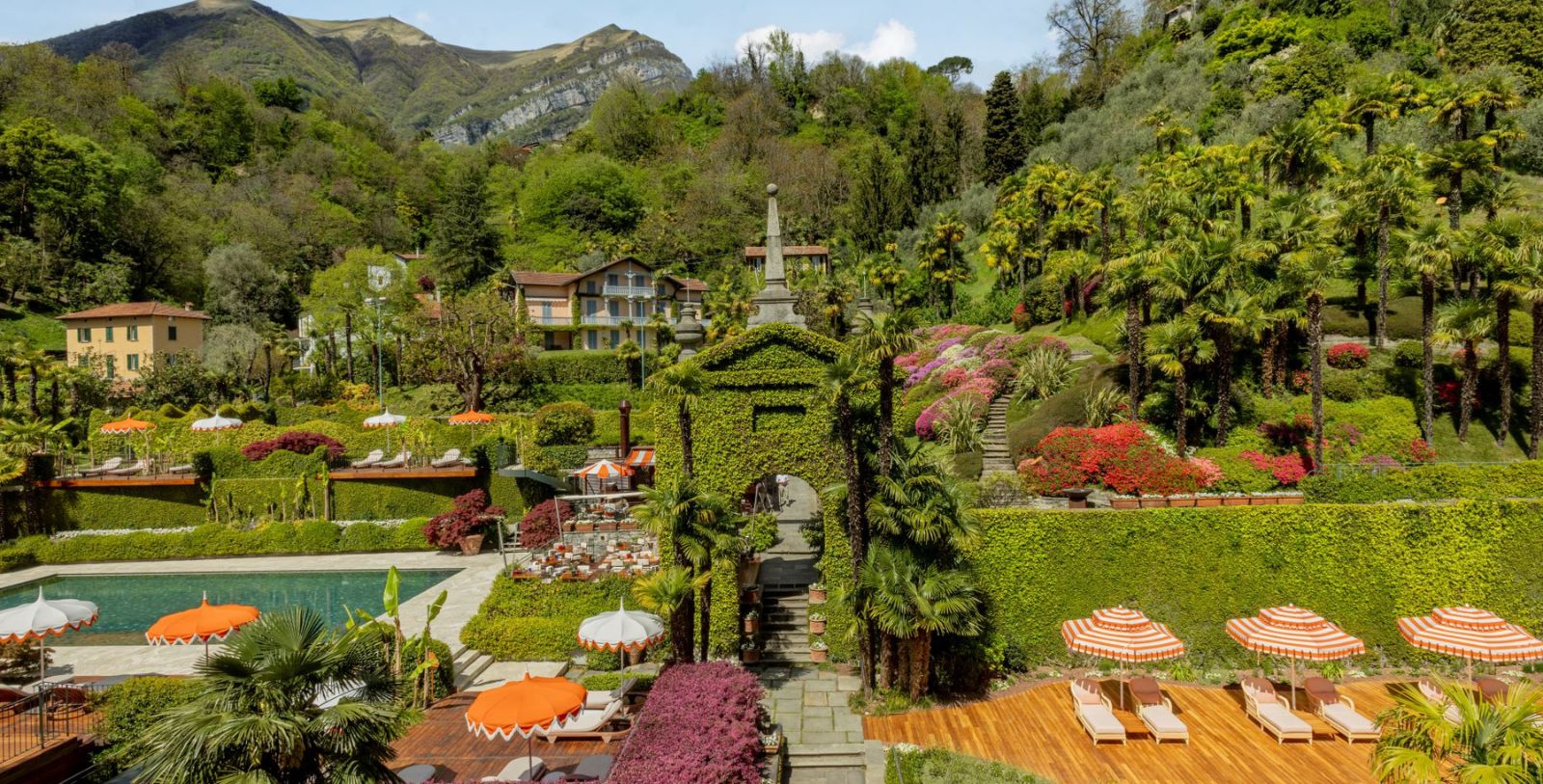a garden with a pool and trees with Butchart Gardens in the background