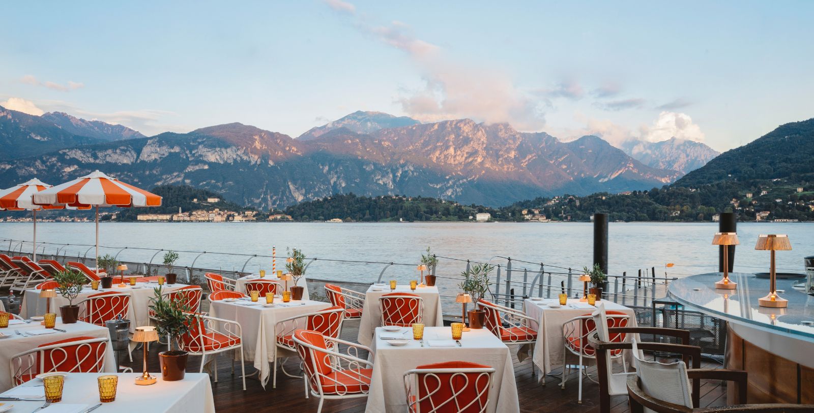 a restaurant with tables and chairs overlooking a body of water