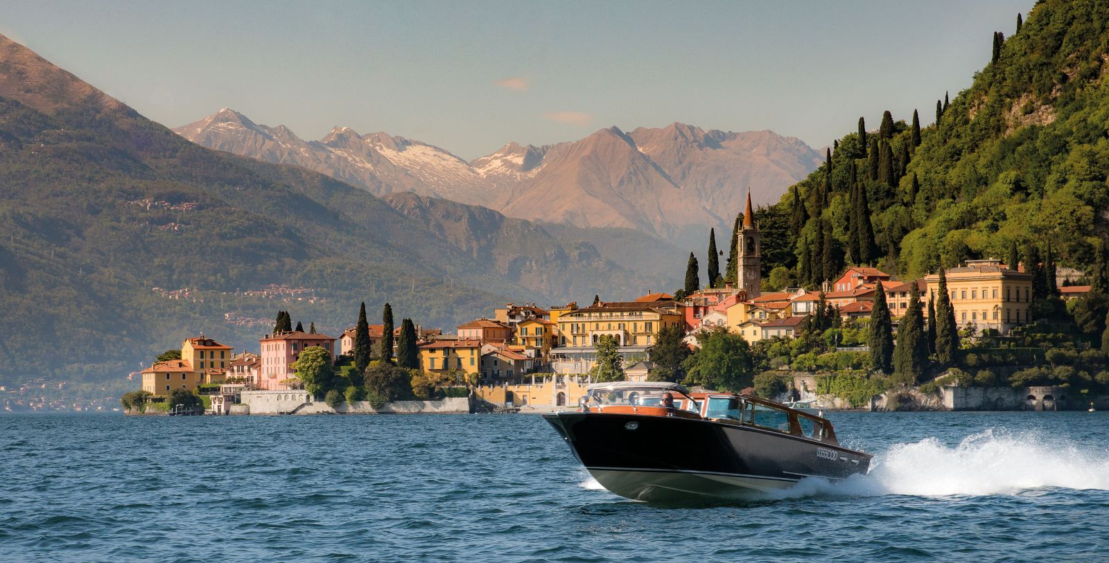 a boat on the water with Lake Como in the background