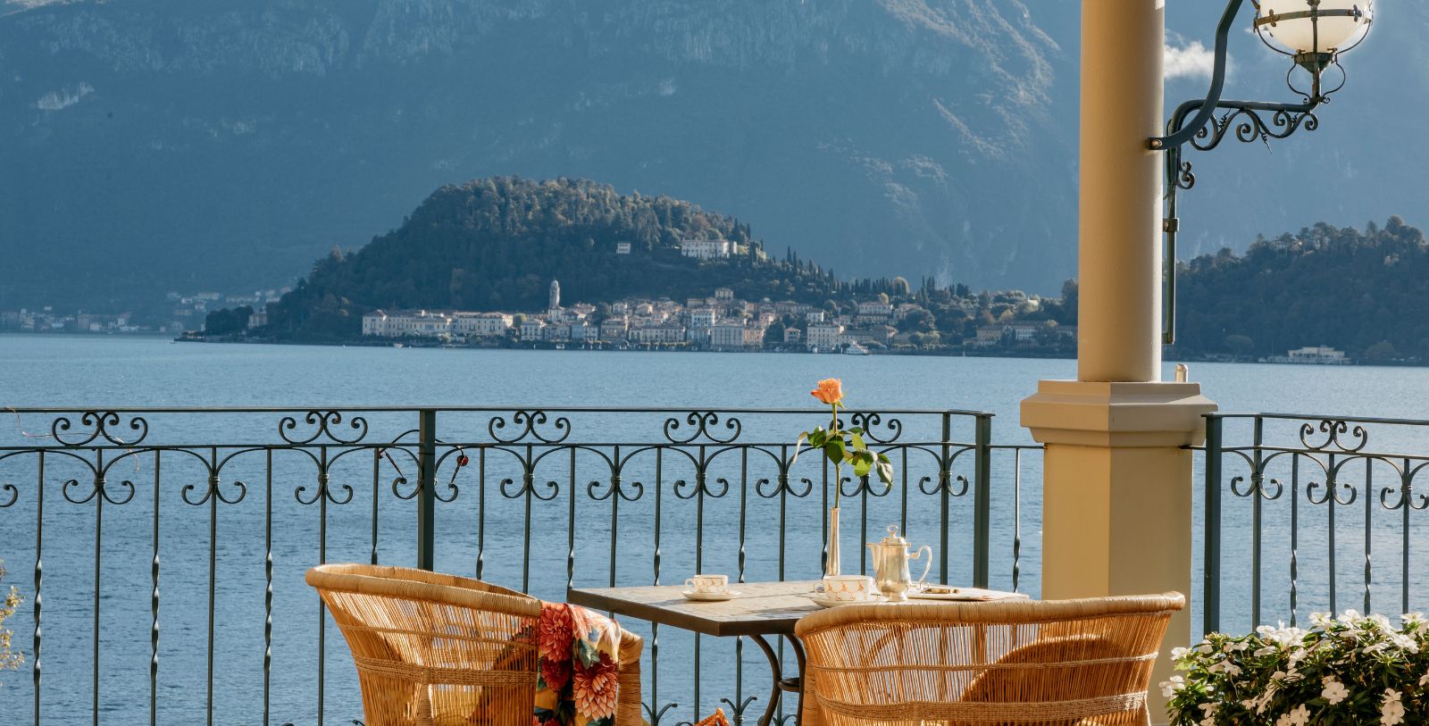 a table and chairs on a balcony overlooking a body of water