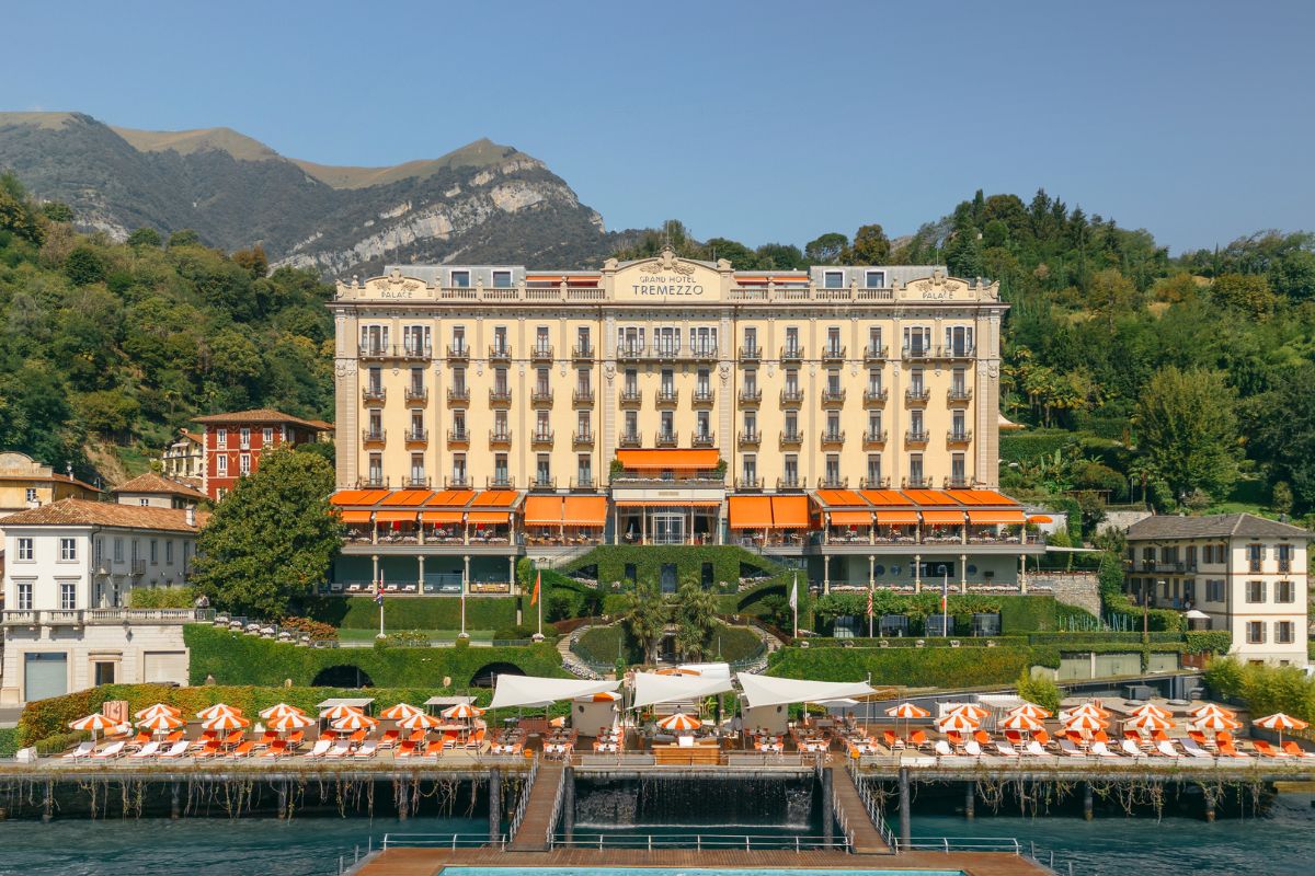 a building with a body of water and a dock with umbrellas
