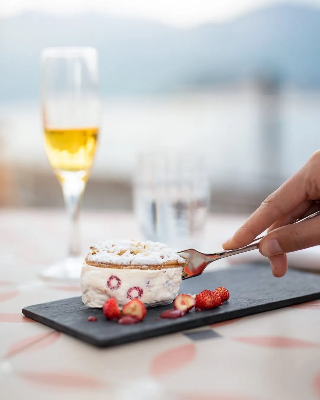 a person holding a fork to a dessert