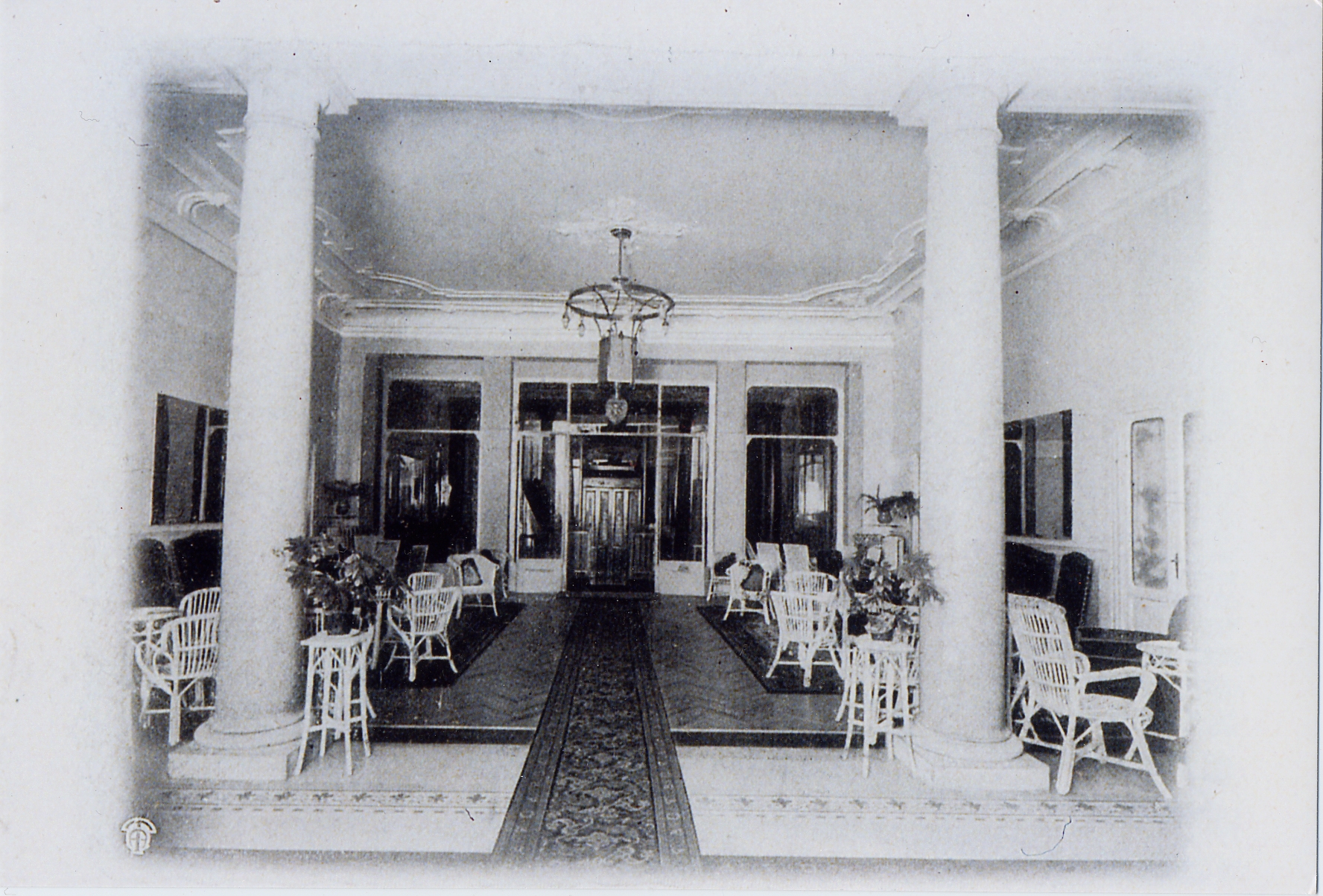 a black and white photo of a room with white chairs and tables