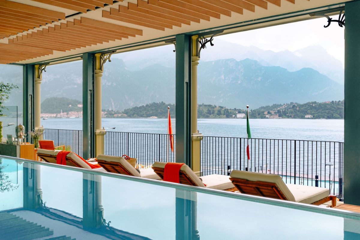 a pool with chairs and a railing overlooking a body of water