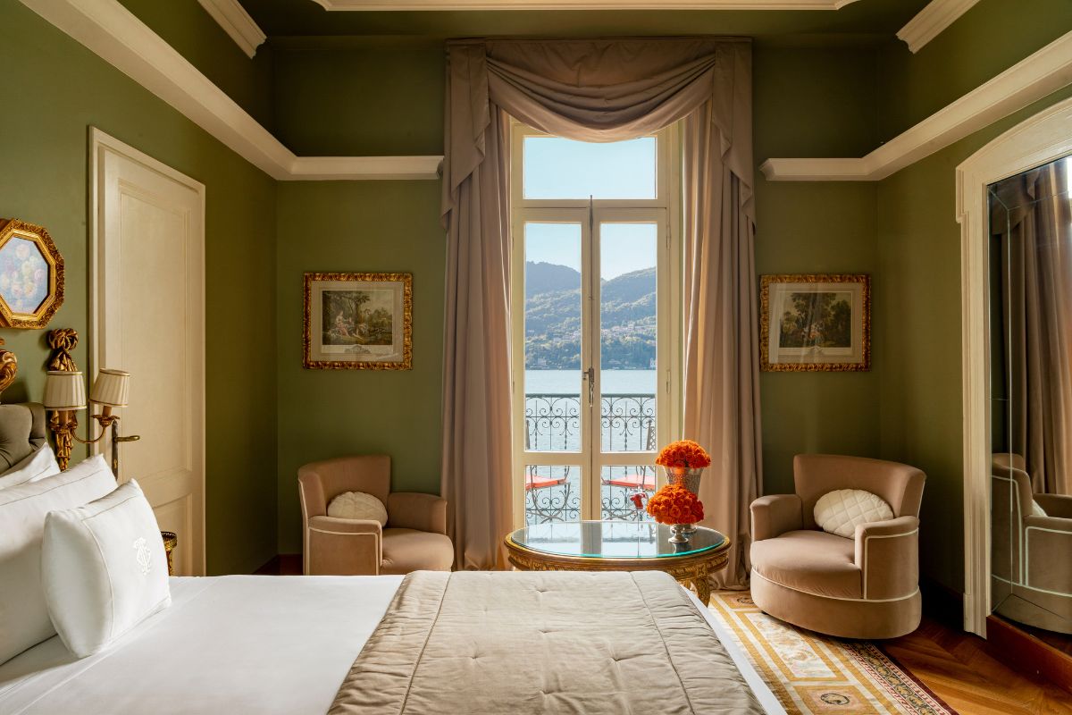 a room with a bed and chairs and a table with flowers