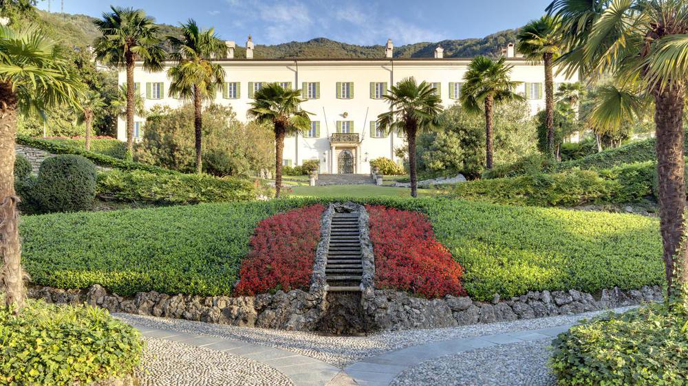 a white building with a garden and a staircase