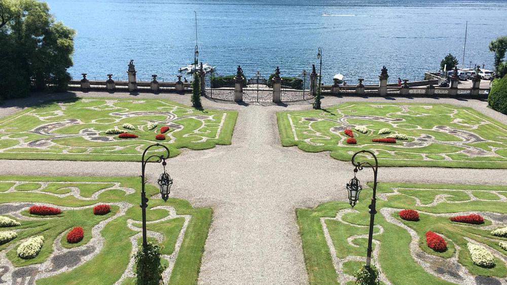 a garden with a gate and a body of water
