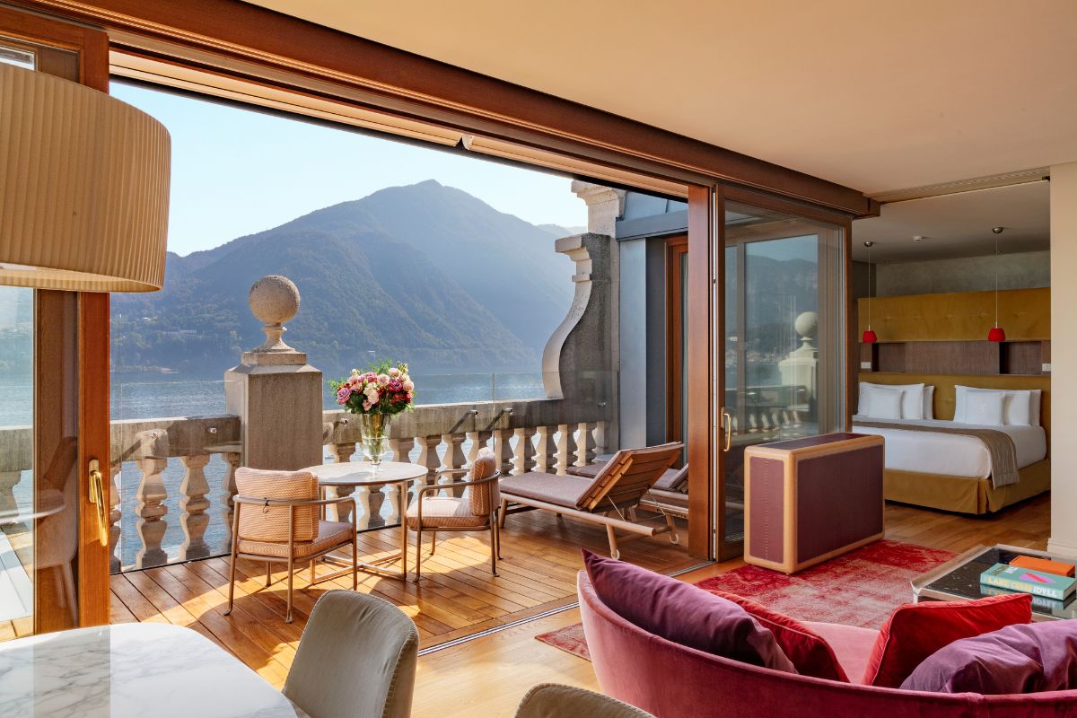 a room with a view of the mountains and water