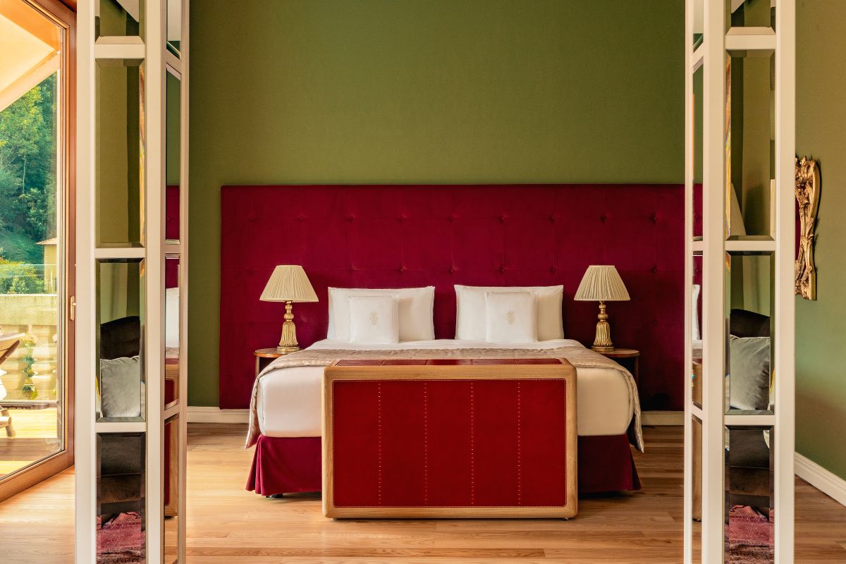 a bed with red headboard and lamps in a room