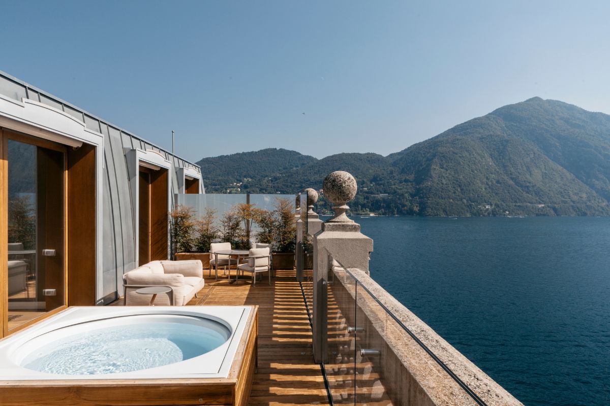 a deck with a hot tub and a large body of water