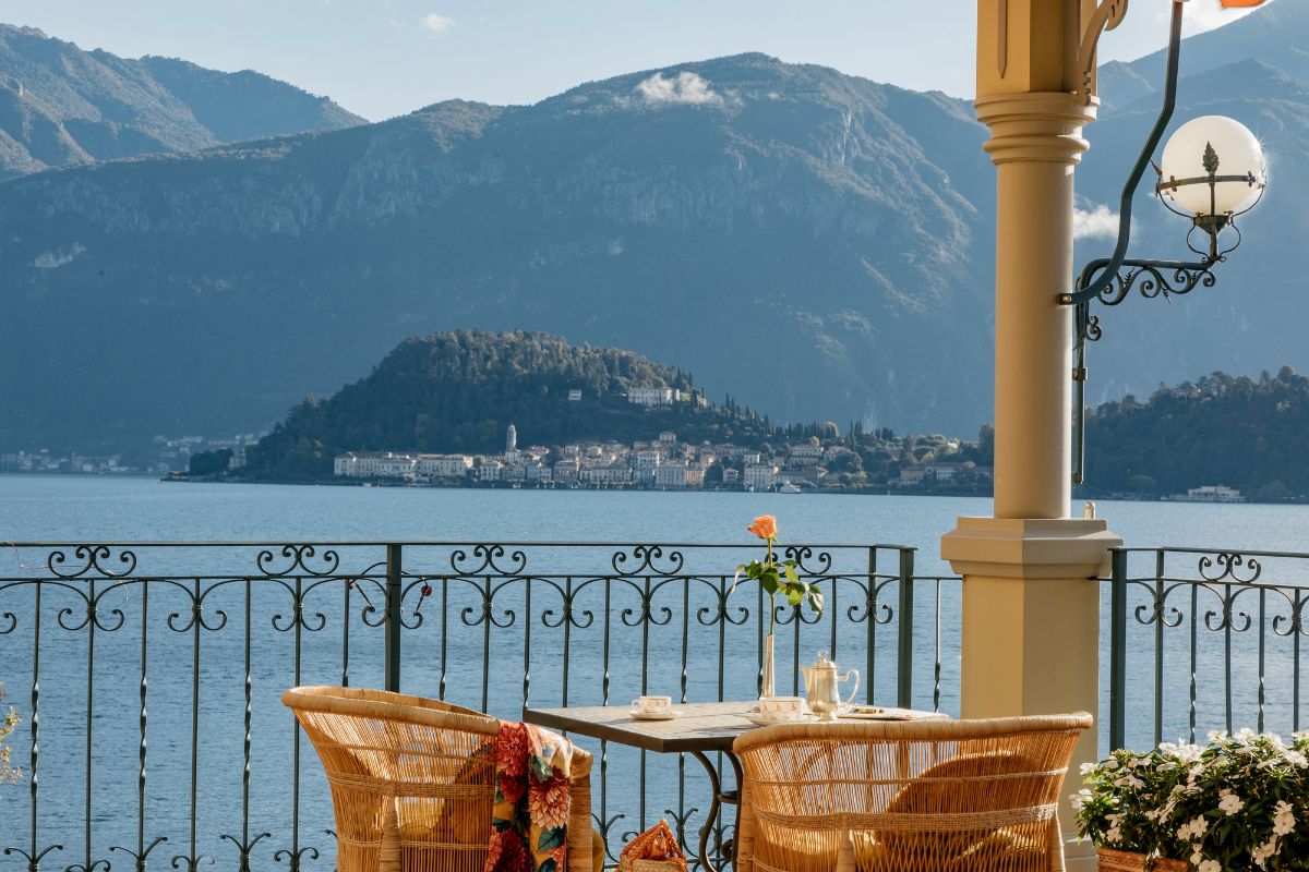 a table and chairs on a balcony overlooking a body of water