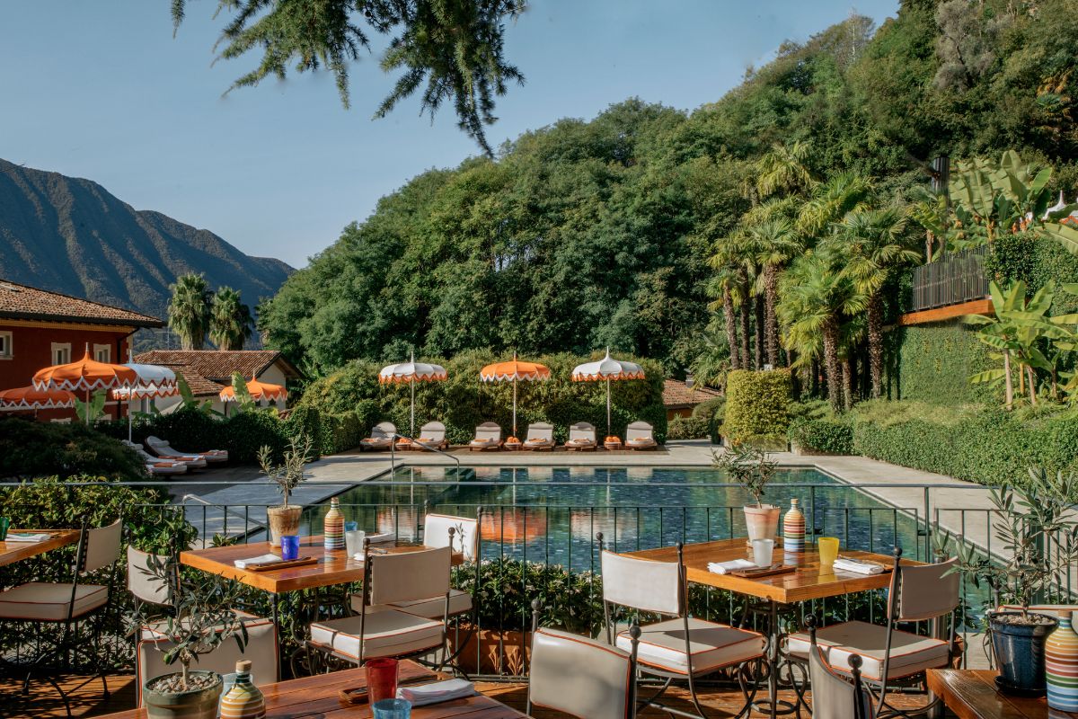 a pool with tables and chairs and trees