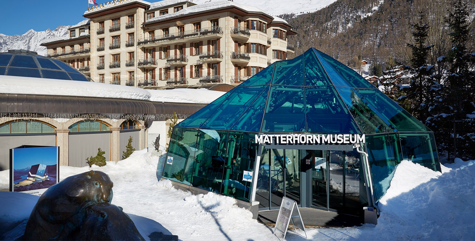 a glass building with a pyramid shaped roof