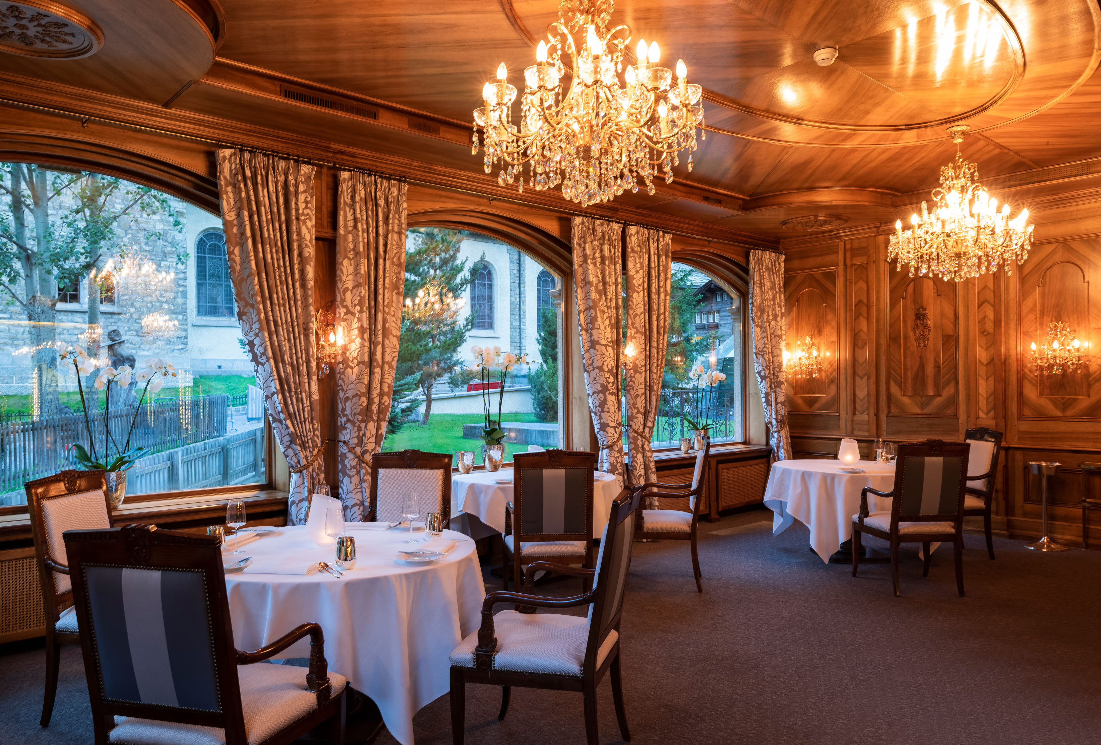a room with tables and chairs and chandeliers