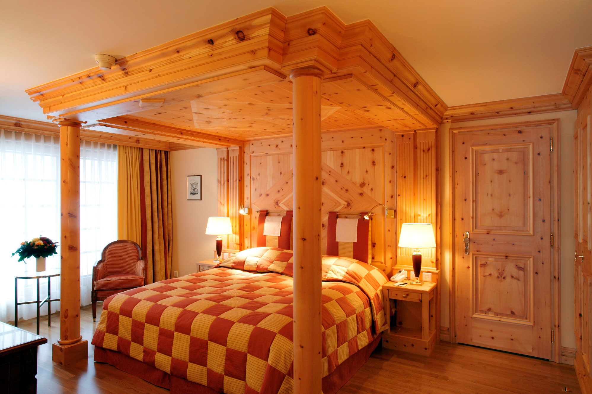 a bed with a wood post and a chair in a room
