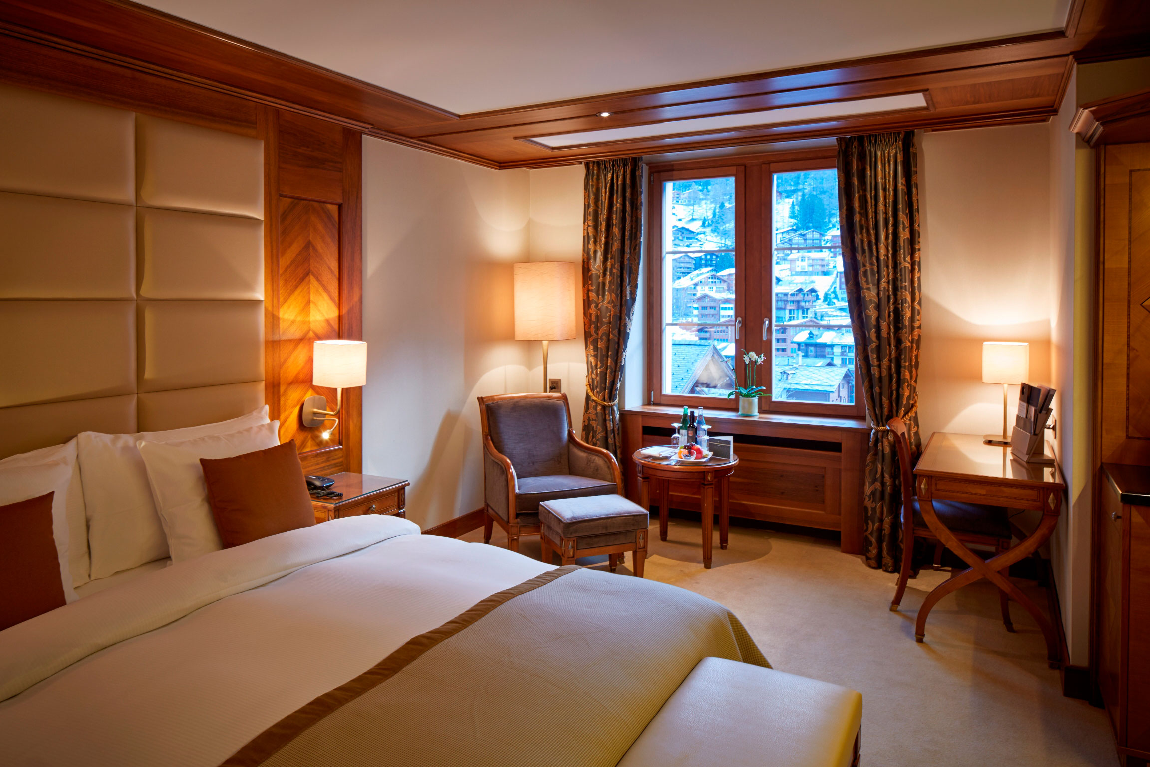 a room with a bed and chairs and a window