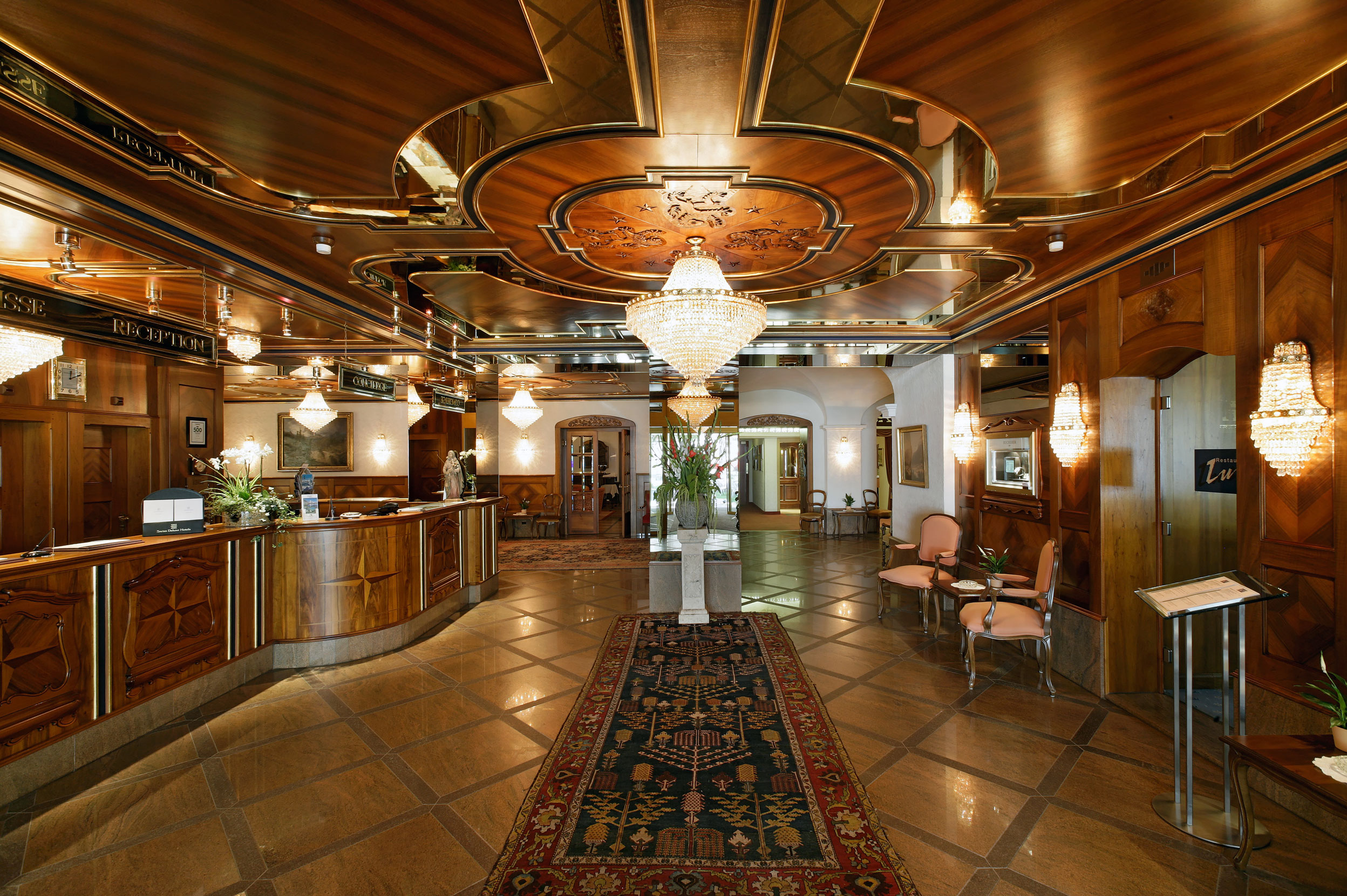 a lobby with a rug and chandeliers