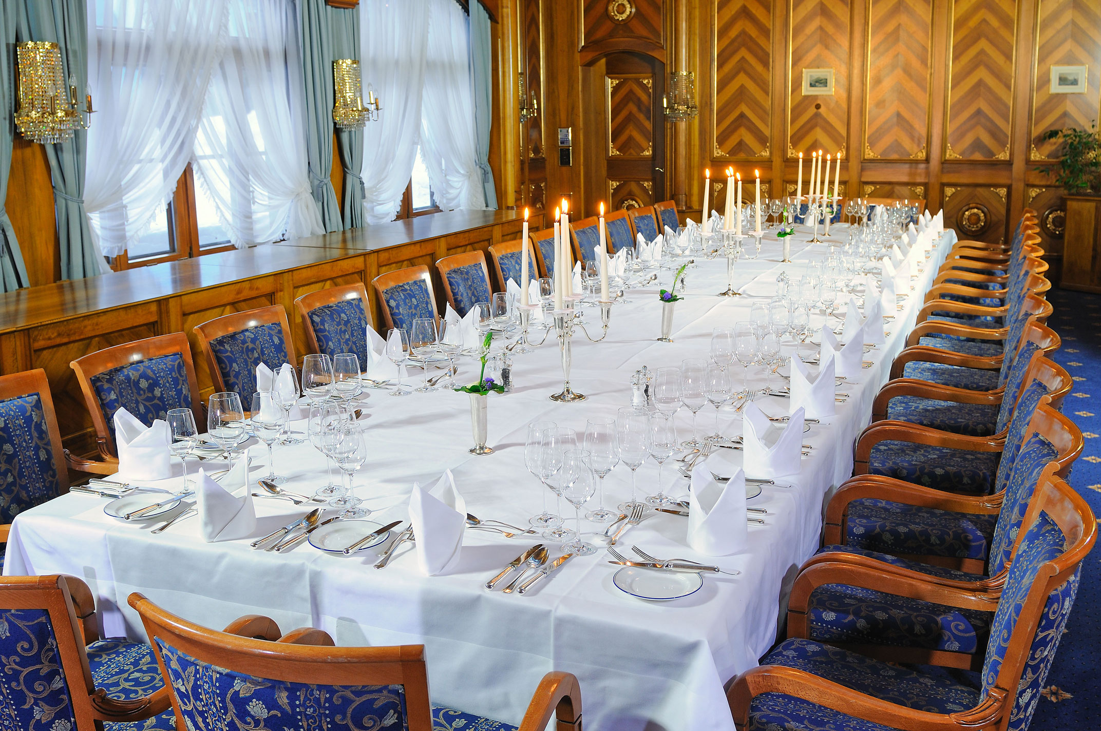a long table with white tablecloths and candles