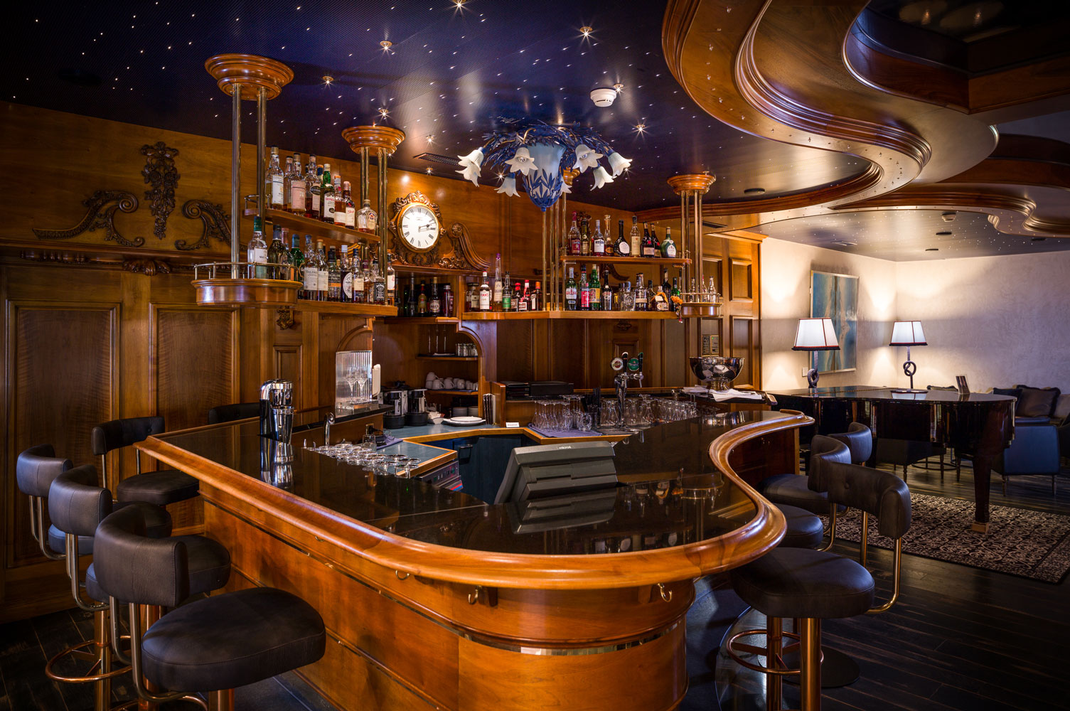 a bar with a counter and shelves of liquor