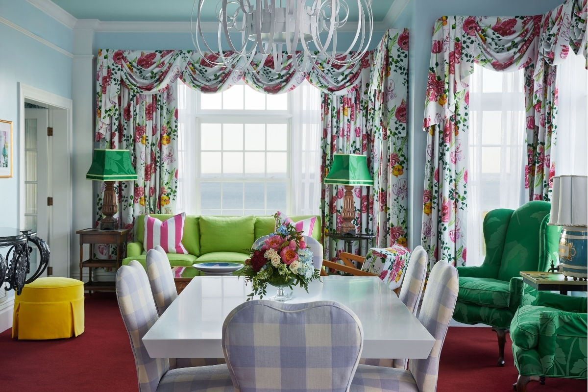 a room with floral curtains and a table and chairs