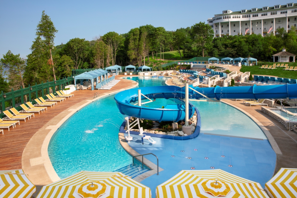 a pool with a slide and umbrellas