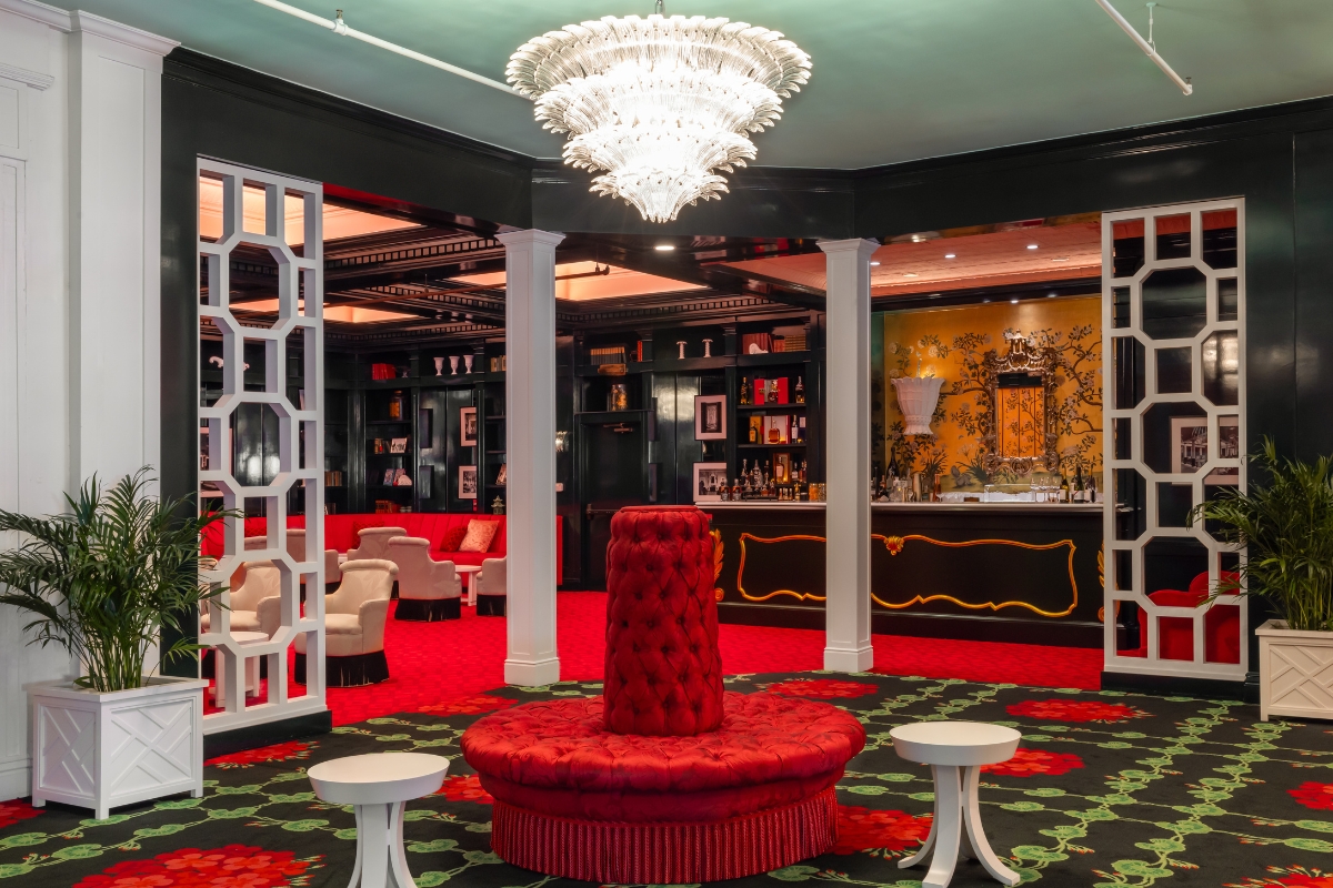 a room with a red couch and a chandelier