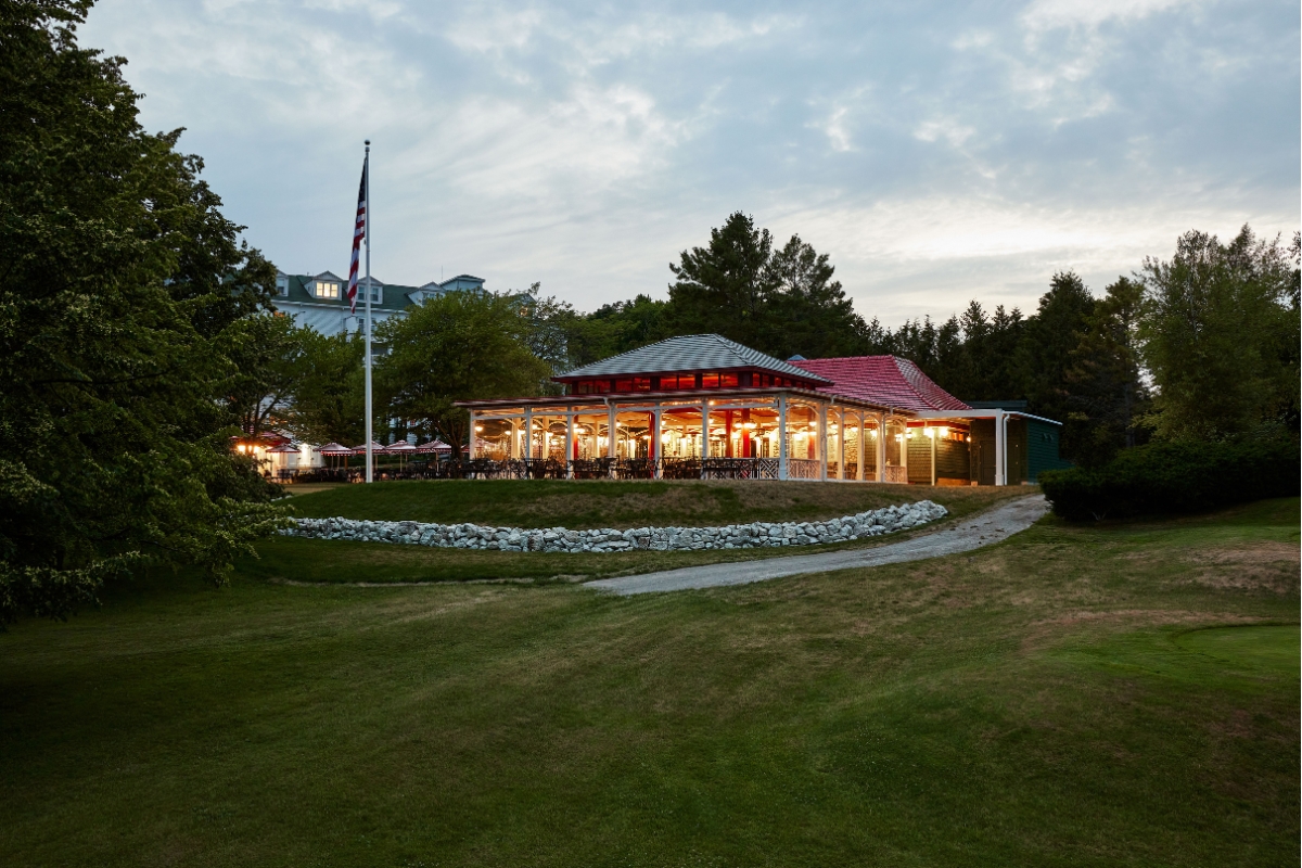 a building with a red roof and a flag in the background