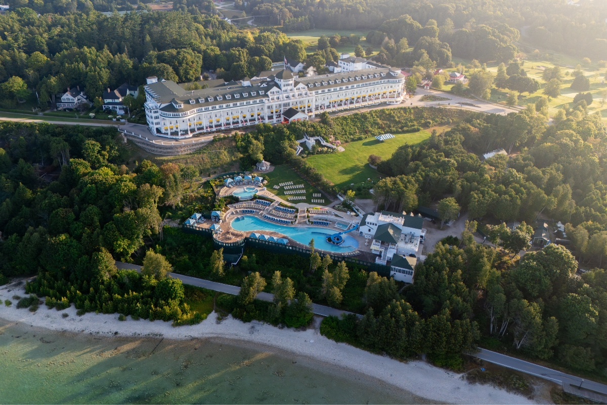 a large building with a pool and trees around it