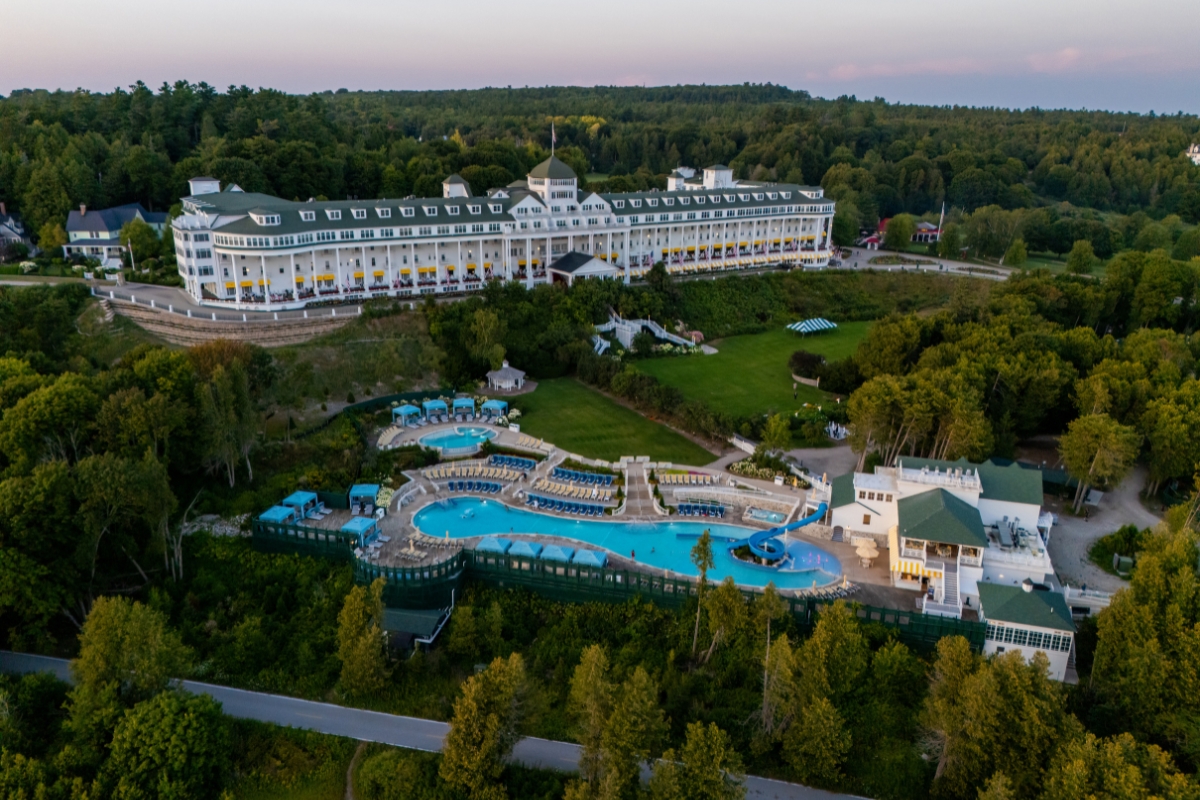 a large hotel with a pool and trees
