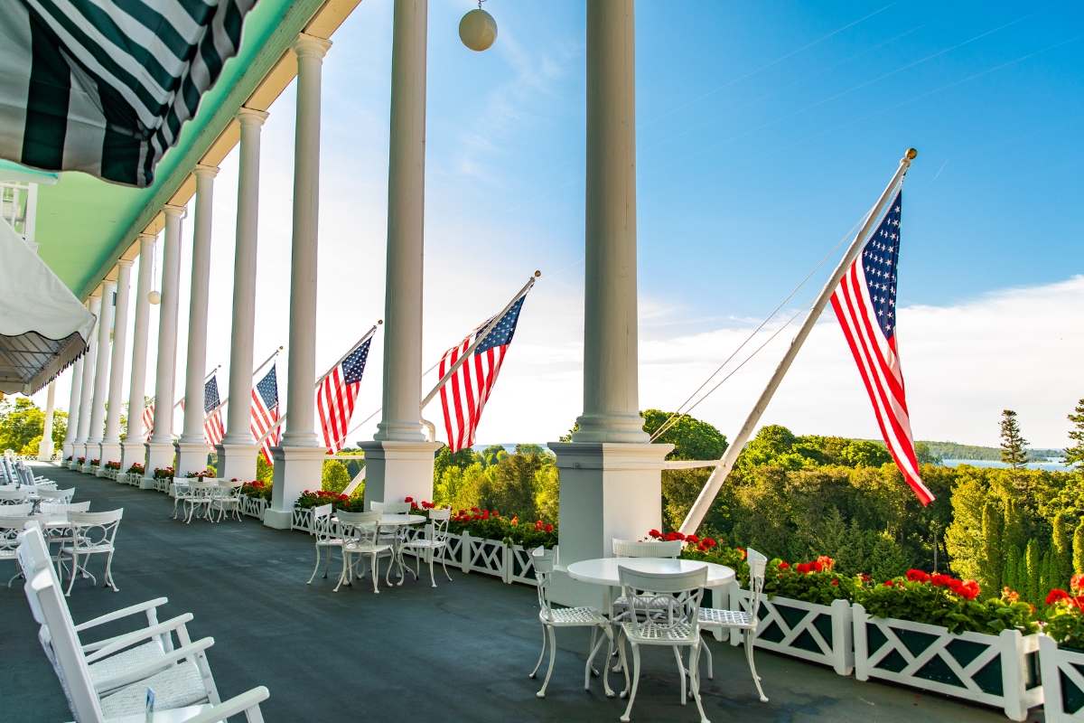 a row of american flags on a porch