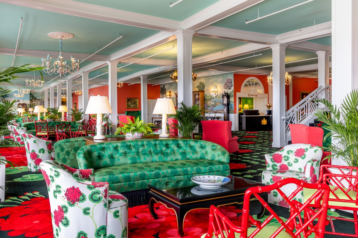 a room with a green couch and red chairs