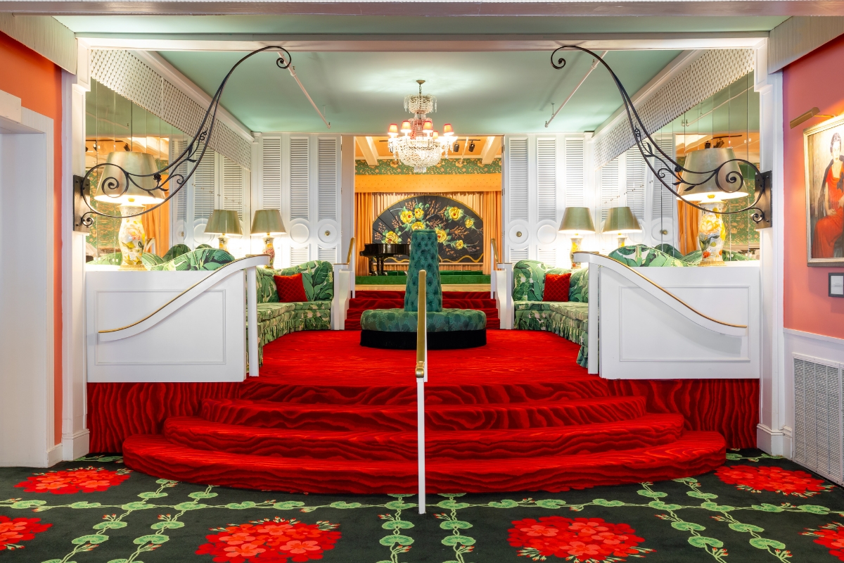 a room with red carpet and green couches