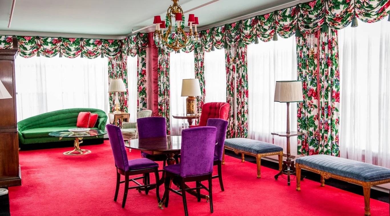 a room with colorful chairs and a chandelier