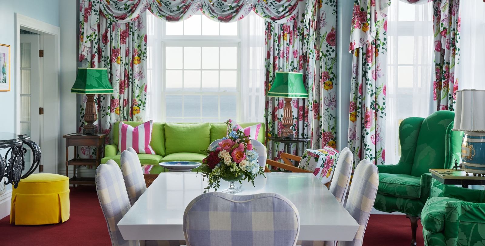 a room with a table and chairs and a green couch