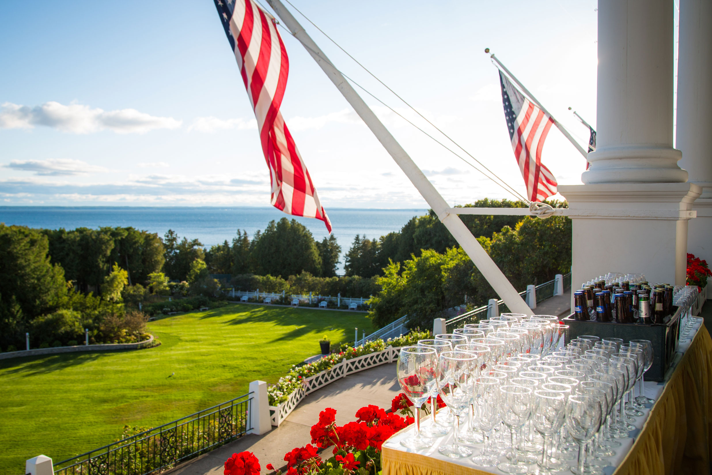 a flag on a flagpole with wine glasses and grass and a lawn