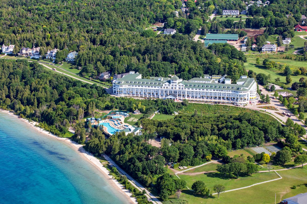 a large building surrounded by trees and a body of water
