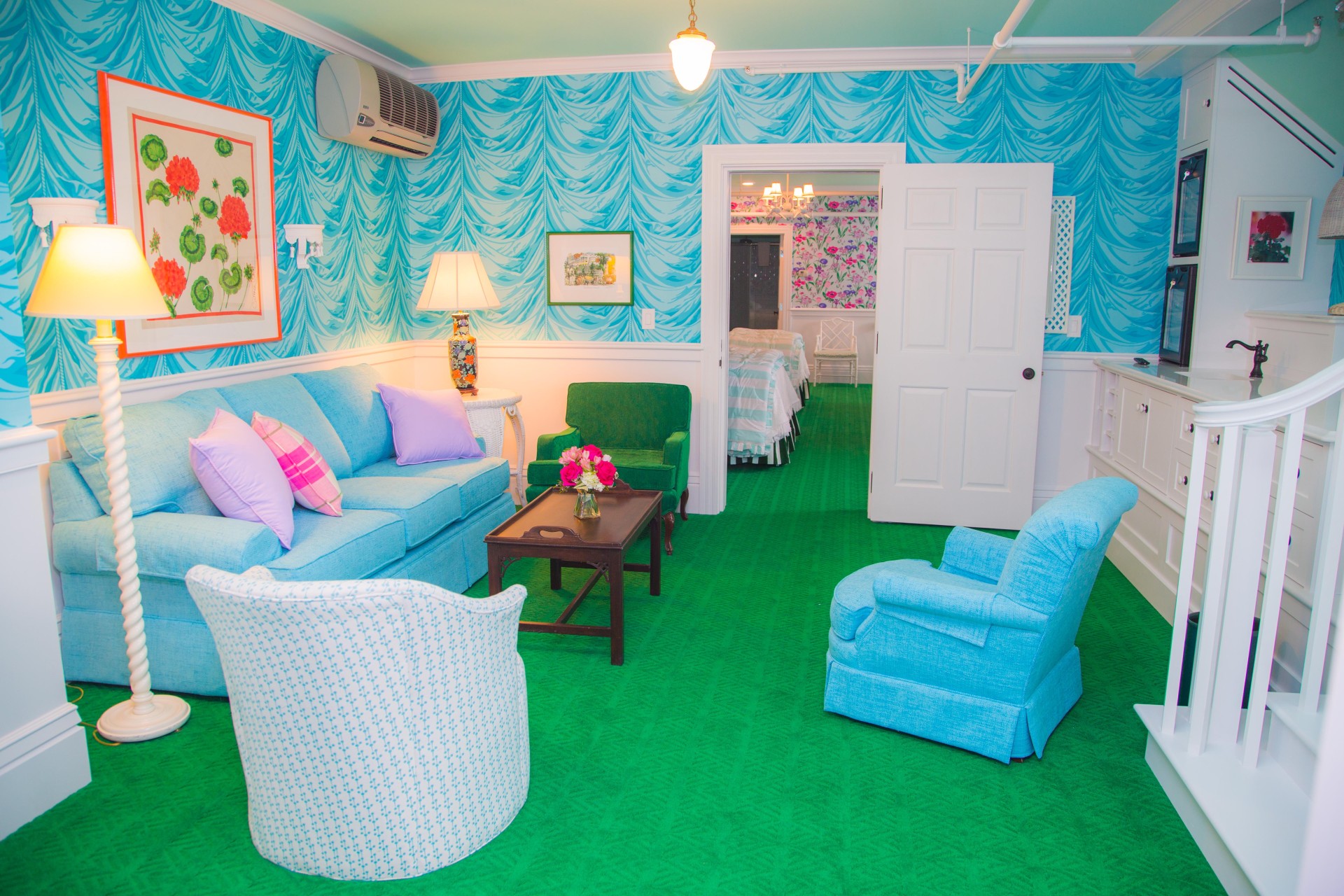 a room with a green carpet and blue couches