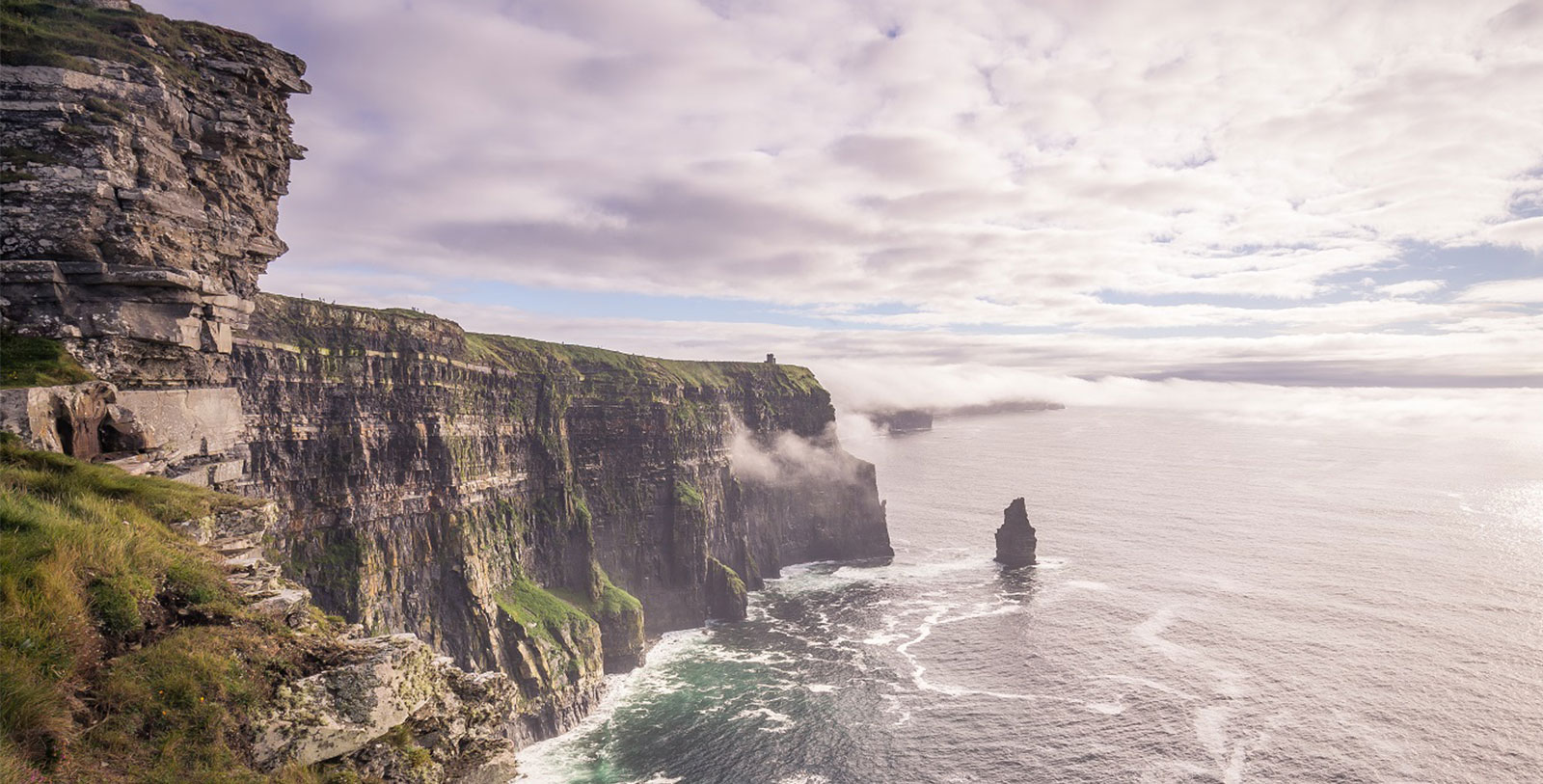 a cliff with water and clouds