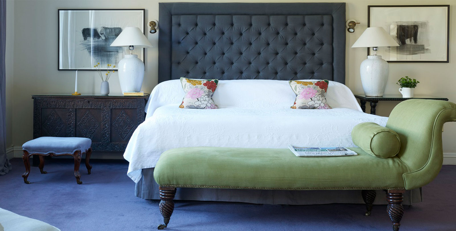 a bed with a green bench and a lamp