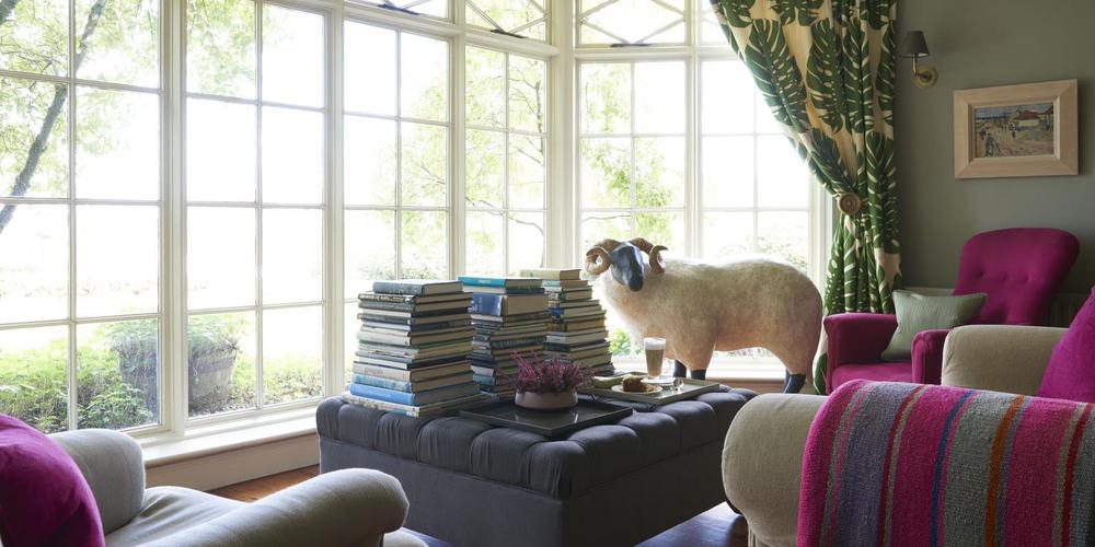 a sheep statue in a room with a table and books
