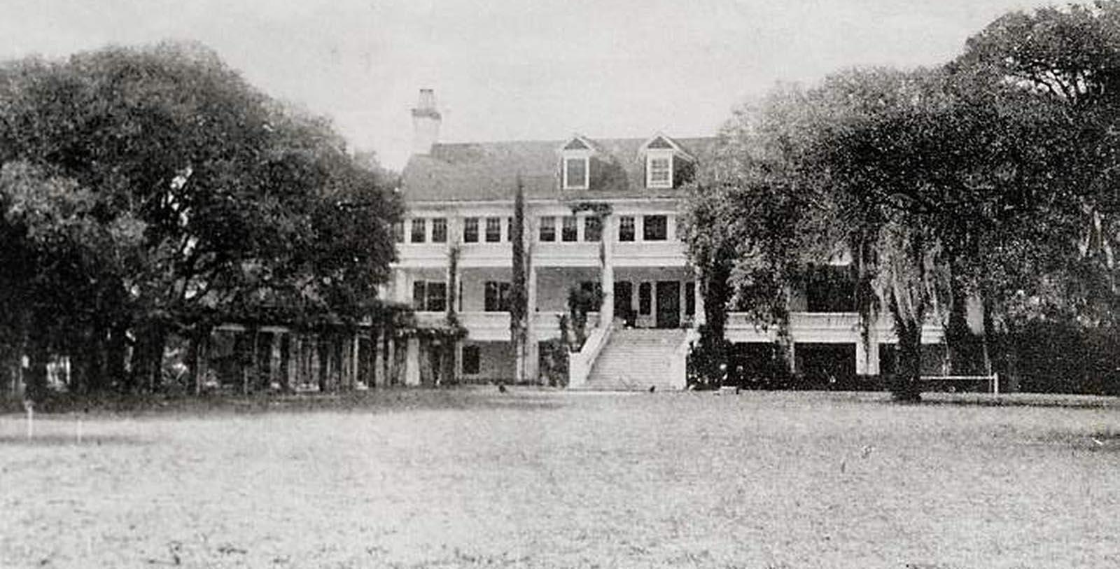 a large building with a lawn and trees