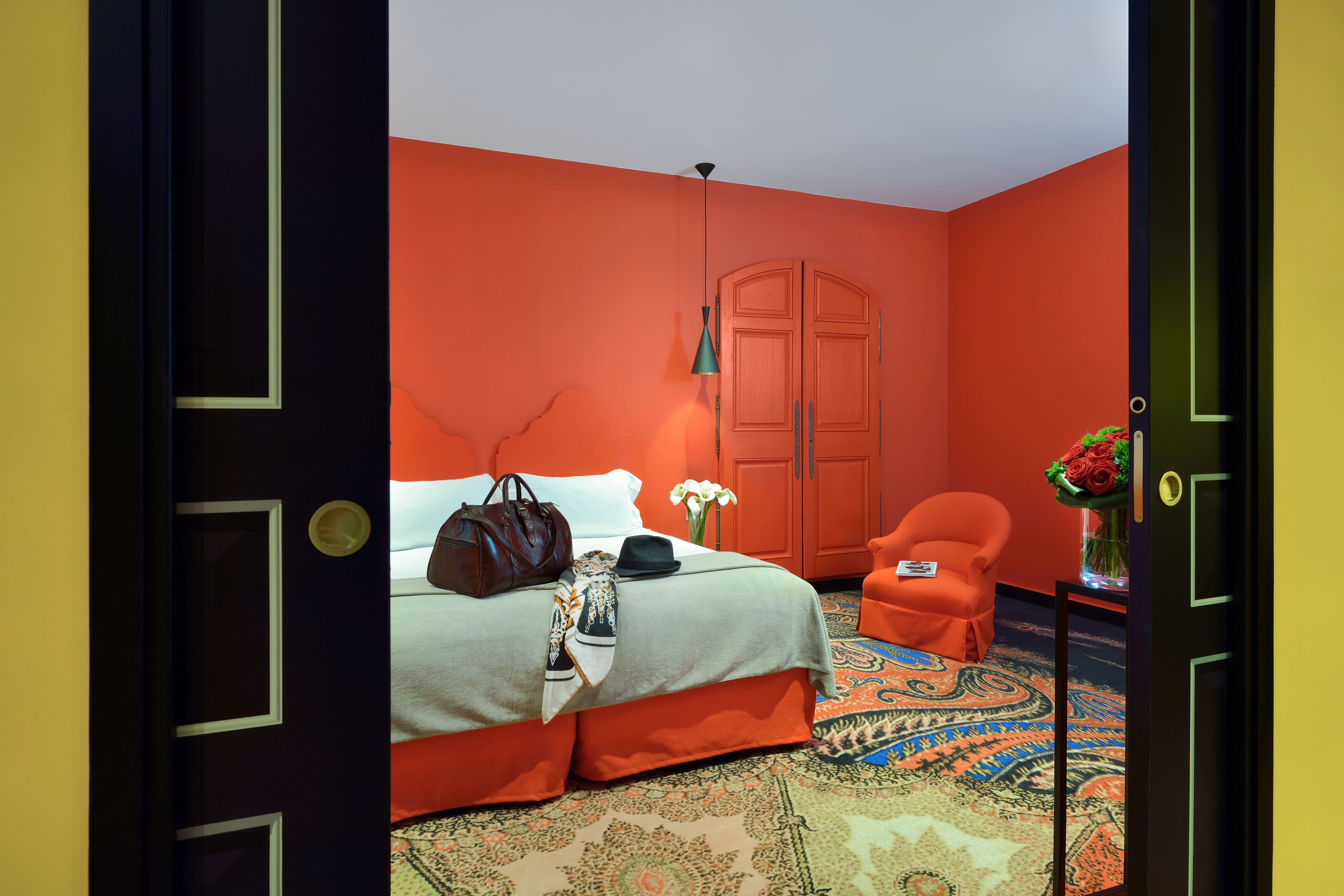 a room with orange walls and a bed and a chair