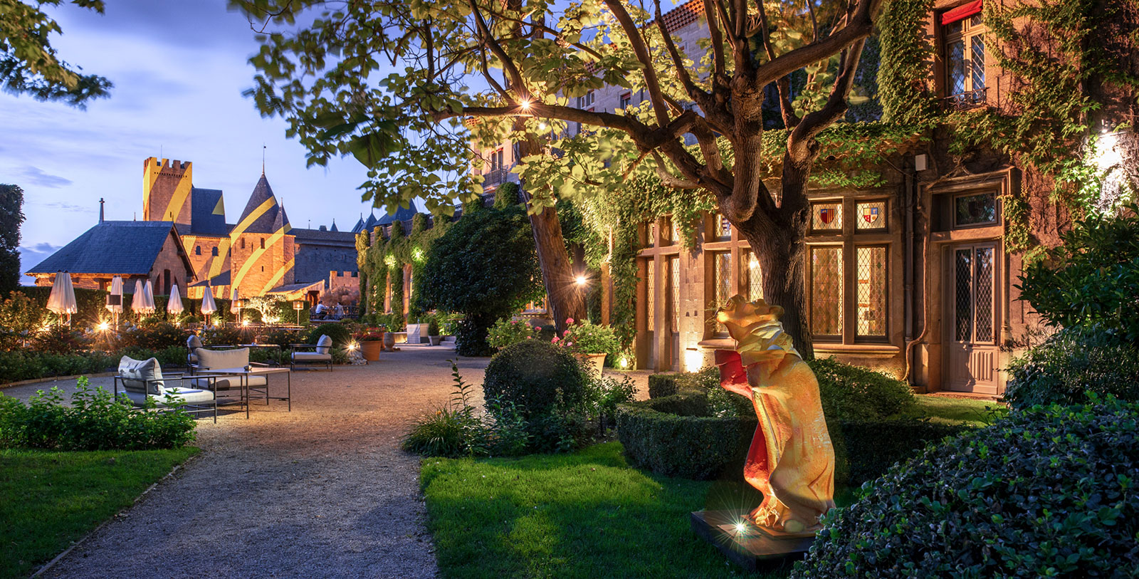 a courtyard with a statue of a bear and a tree