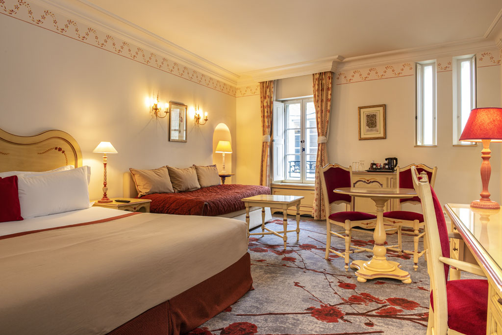 a room with two beds and a table and chairs