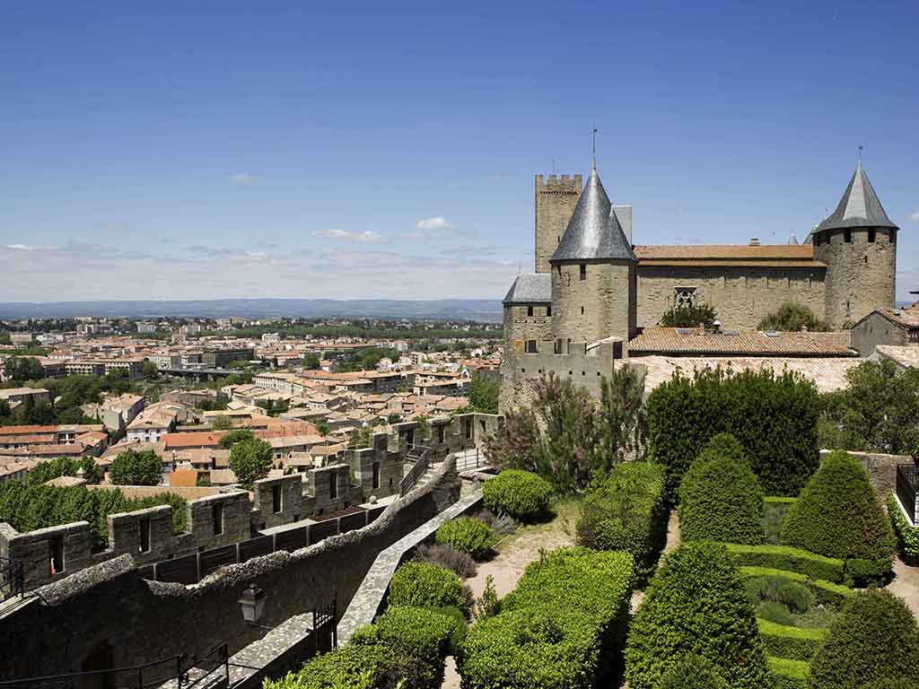 a castle with a garden and a city in the background